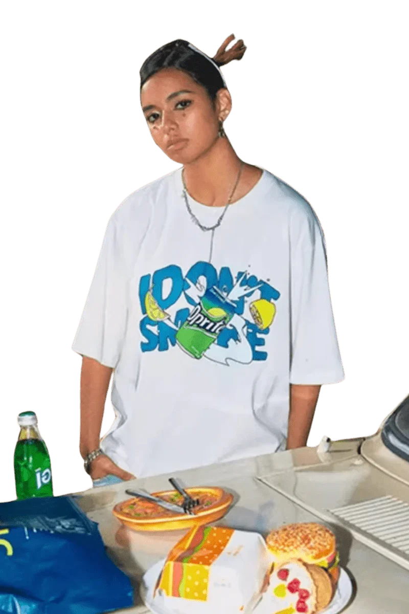 Woman wearing white IDontSmoke Drinks Series Tee with colorful graphic by a table with snacks and drinks