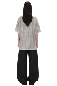 Back view of a model wearing Masonprince Dirty 150GSM Tee in light gray with loose black pants