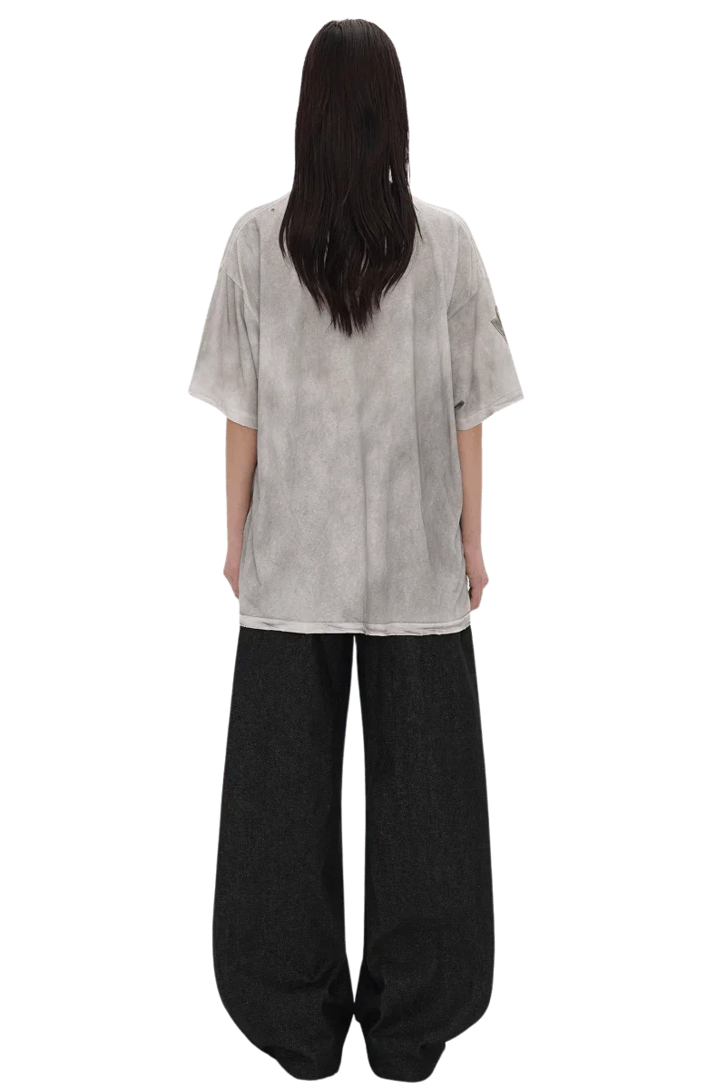 Back view of a model wearing Masonprince Dirty 150GSM Tee in light gray with loose black pants