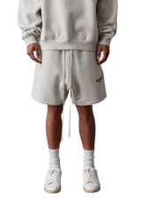 Casual model wearing SS22 Flocked Logo Shorts in grey with a relaxed fit and drawstring waist