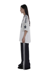 Side view of model wearing Masonprince 90s star mesh tee with star and stripe details on sleeves