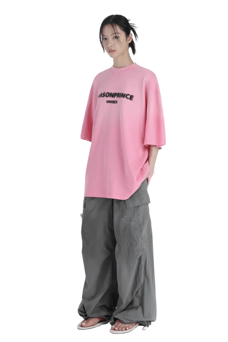 Masonprince 2.0 Faded Logo Gradient Tee in pink worn by a model with gray wide-leg pants