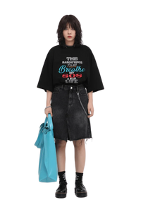 Model wearing black Masonprince 808 Breathe Tee with graphic text paired with black denim skirt and blue tote bag