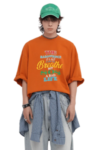 Masonprince 808 Breathe Tee in orange worn by model with green cap and layered casual outfit