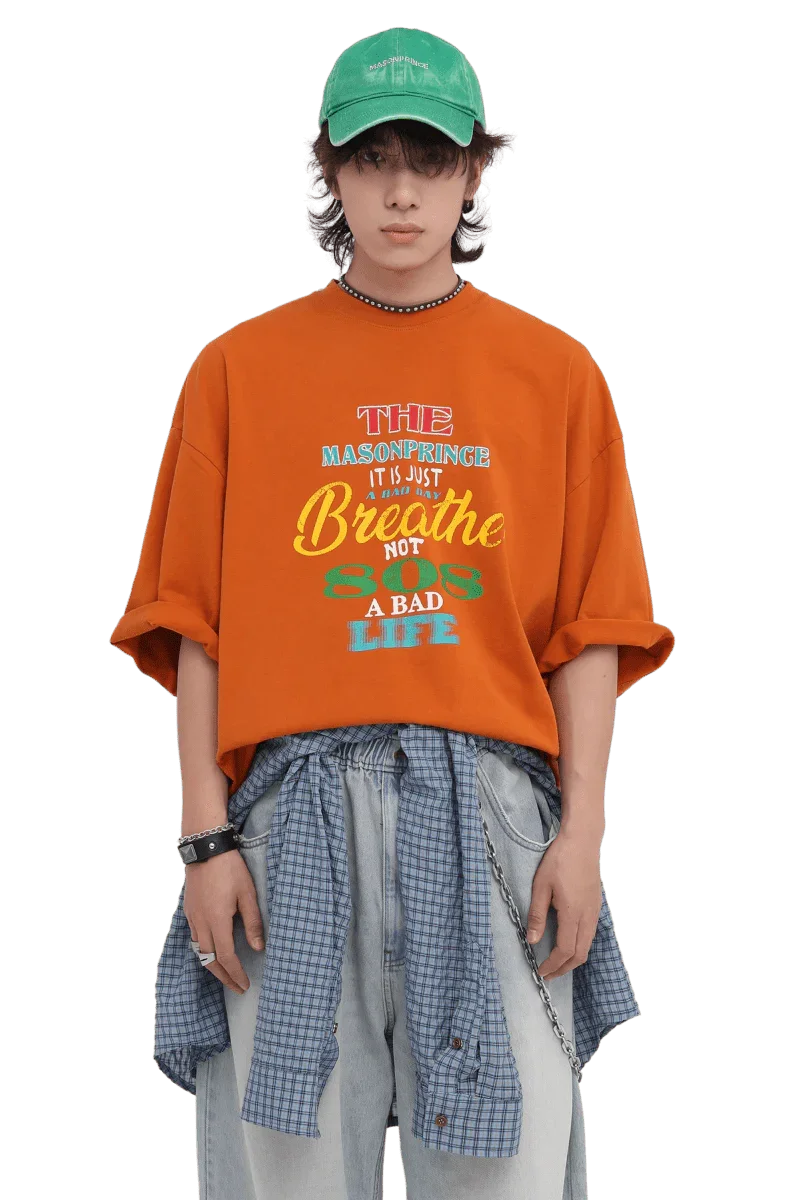 Masonprince 808 Breathe Tee in orange worn by model with green cap and layered casual outfit
