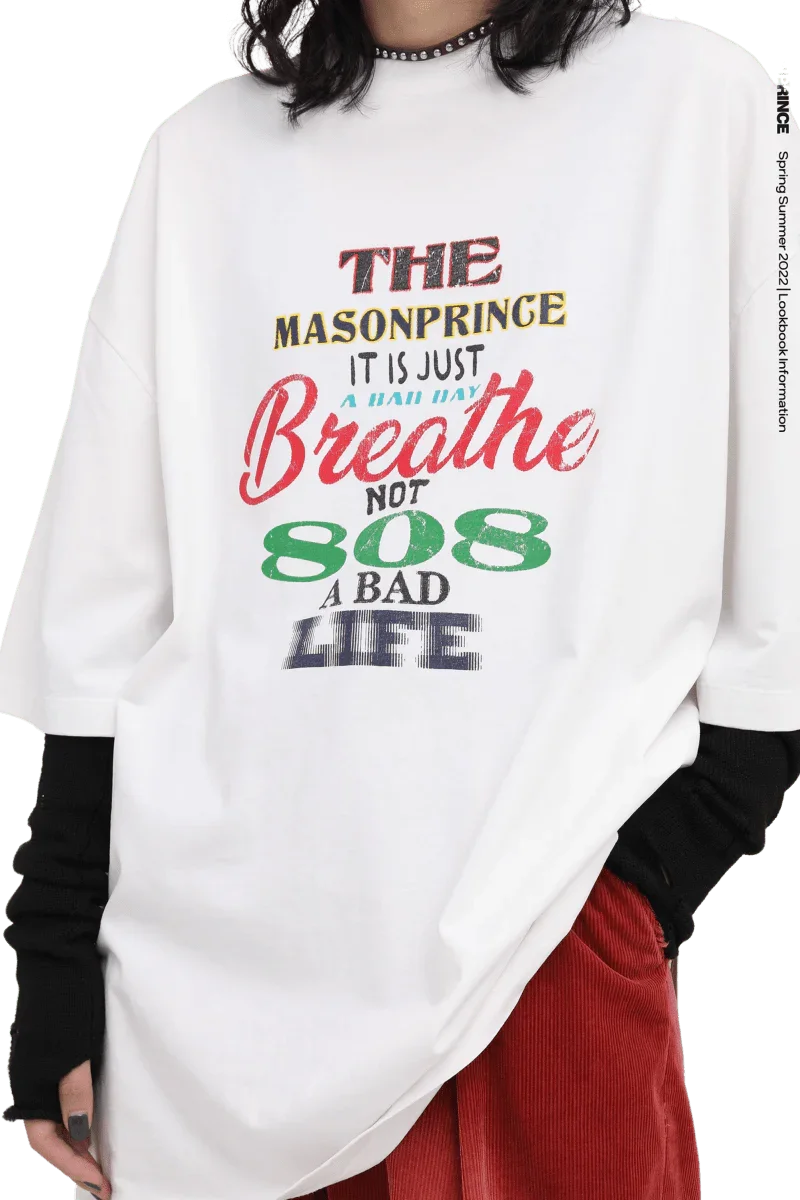 White Masonprince 808 Breathe Tee with colorful text design worn with black sleeves and red pants