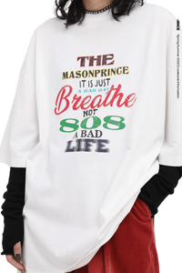 White Masonprince 808 Breathe Tee with colorful text design worn with black sleeves and red pants