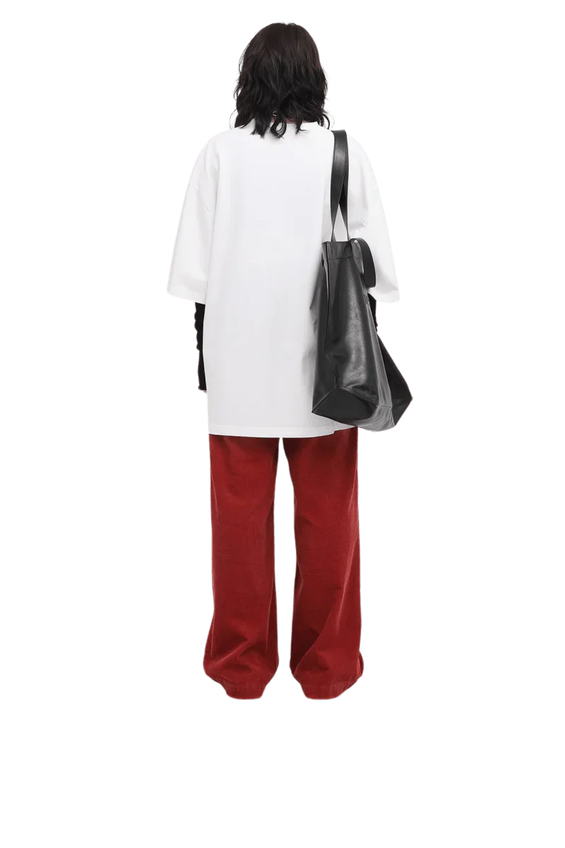 Back view of a person wearing a white Masonprince 808 Breathe Tee with red pants and carrying a black tote bag