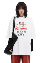 White Masonprince 808 Breathe Tee with multicolor text worn by model with black layered sleeves and black bag