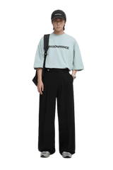 Model wearing Masonprince Basic Logo Tee in light blue with relaxed fit and black wide-leg pants