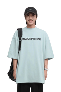 Masonprince Basic Logo Tee in light blue with oversized fit, worn by a smiling model holding a backpack