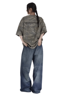 Back view of a woman wearing a Masonprince camouflage tee paired with wide-leg blue jeans