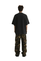 Back view of a man wearing Masonprince Champion League Tee with cargo pants in a casual style