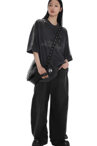 Model wearing Masonprince Champion League Tee black oversized shirt with bag and wide black pants