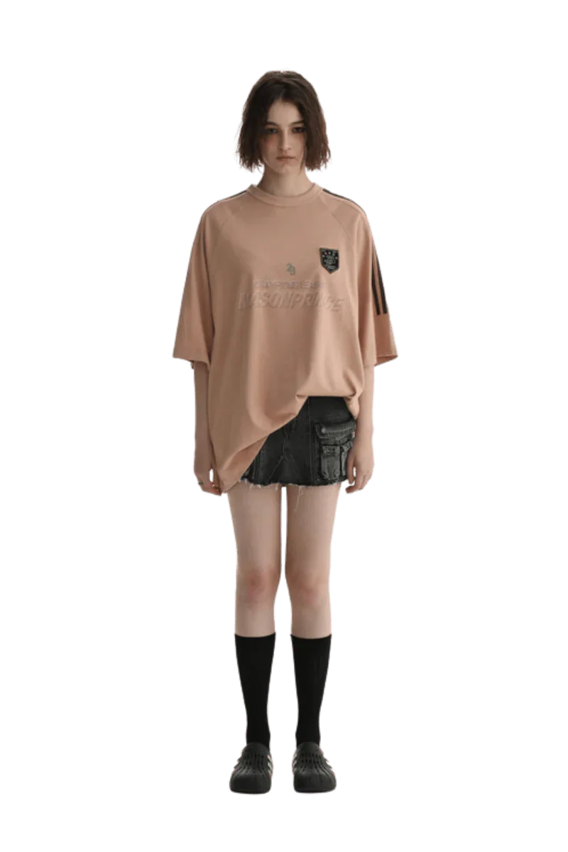 Masonprince Champion League Tee in soft peach color, styled with black shorts and knee-high socks