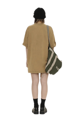 Back view of person wearing Masonprince colorful star tee oversized brown dress with black beanie and striped shoulder bag