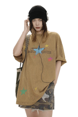 Masonprince colorful star tee worn by model with black beanie and headphones paired with a camo skirt