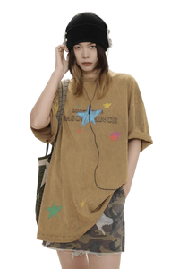 Masonprince colorful star tee worn by model with black beanie and headphones paired with a camo skirt