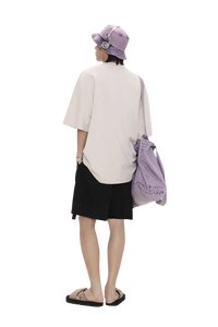 Back view of person wearing Masonprince colorful star tee oversized with black shorts and purple bucket hat and bag