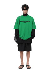 Model wearing Masonprince Faded Logo Tee in bright green with layered streetwear style
