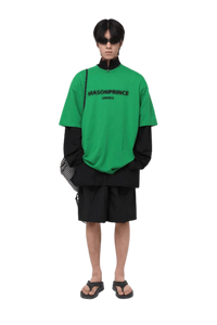 Model wearing Masonprince Faded Logo Tee in bright green with layered streetwear style
