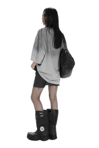 Woman wearing Masonprince Gradient Tee gray oversized shirt with black shorts and boots