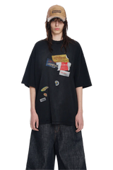 Masonprince patchwork tee in black with multiple colorful fabric patches styled with wide denim pants and a tan cap