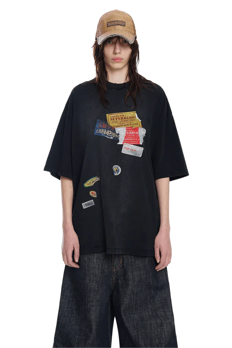 Masonprince patchwork tee in black with multiple colorful fabric patches styled with wide denim pants and a tan cap