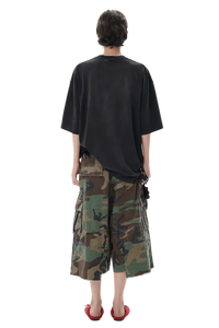 Back view of a model wearing Masonprince patchwork tee in black with camouflage cargo shorts