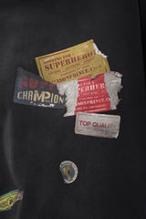 Close-up of Masonprince patchwork tee showing multiple distressed vintage-style fabric patches on black material
