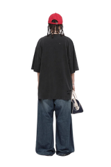 Back view of model wearing Masonprince black Real World Tee with loose fit and distressed details