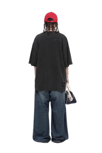 Back view of model wearing Masonprince black Real World Tee with loose fit and distressed details