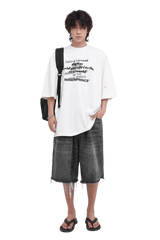 Masonprince white Real World Tee with black text worn with gray denim shorts and black sandals