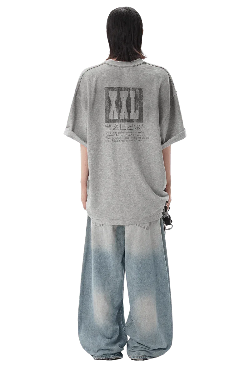 Back view of a person wearing a gray Masonprince reversed style tee with graphic print and loose faded jeans