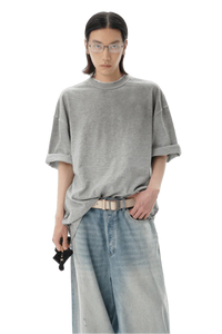 Model wearing a gray Masonprince reversed style tee with rolled sleeves and light wash jeans