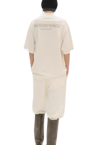 Back view of person wearing Masonprince Spokesman tee in off-white with matching pants and black hat