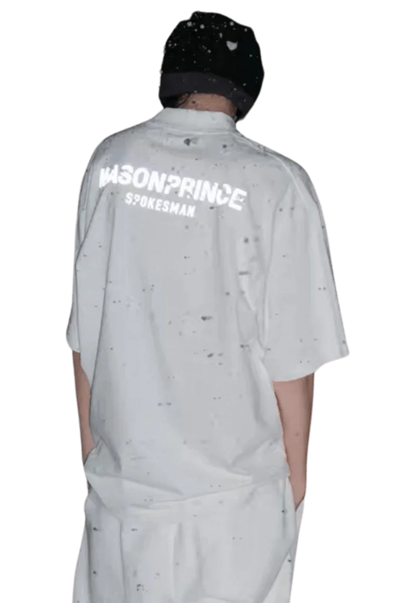 Back view of a person wearing a white Masonprince Spokesman tee with black speckled design and a black beanie