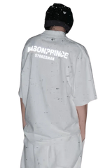 Back view of a person wearing a white Masonprince Spokesman tee with black speckled design and a black beanie