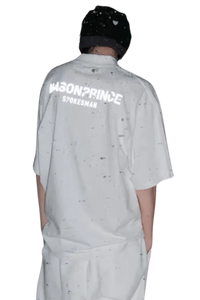 Back view of a person wearing a white Masonprince Spokesman tee with black speckled design and a black beanie