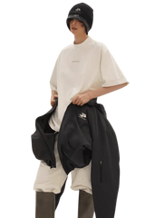 Model wearing Masonprince Spokesman tee in white with oversized fit and black outerwear
