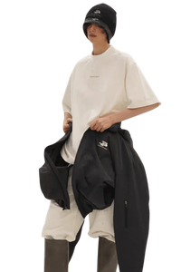 Model wearing Masonprince Spokesman tee in white with oversized fit and black outerwear