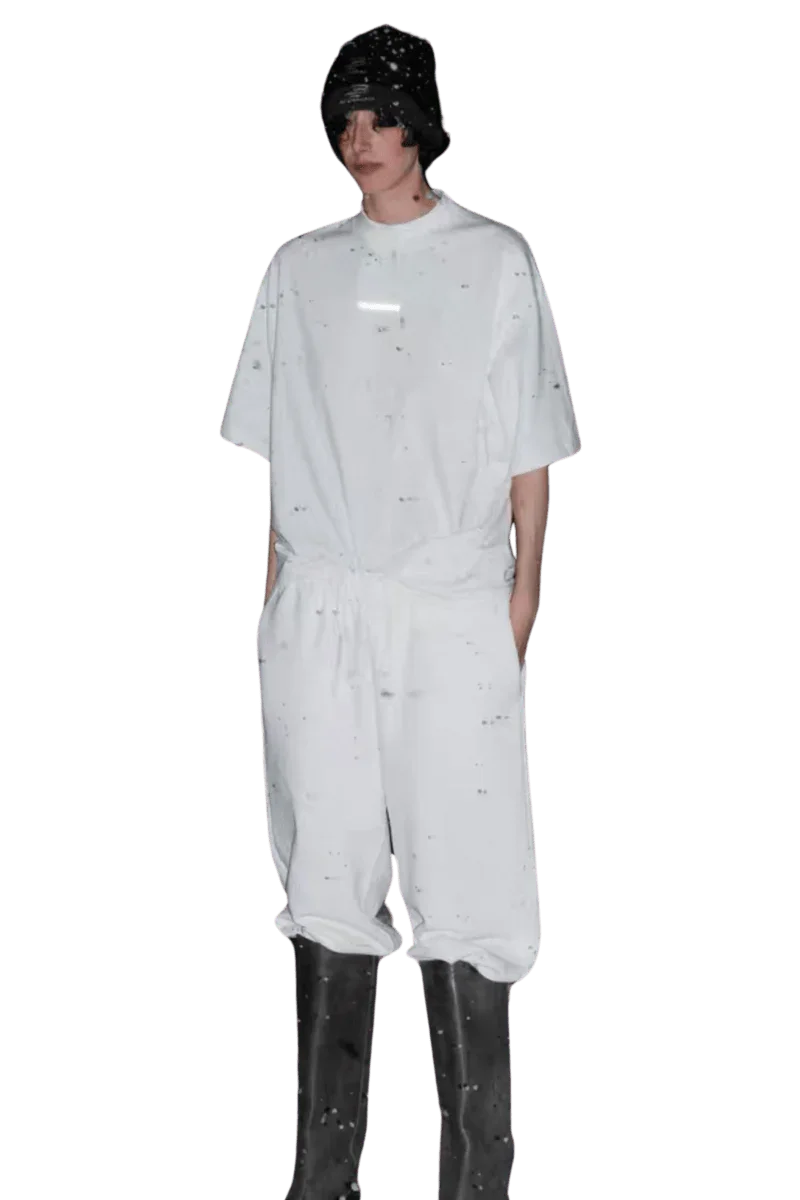 Model wearing white Masonprince Spokesman tee with matching pants and black boots on black background