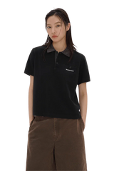 Woman wearing black Masonprince SS25 Polo Tee with checkered collar and brown pants