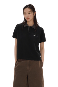 Woman wearing black Masonprince SS25 Polo Tee with checkered collar and brown pants