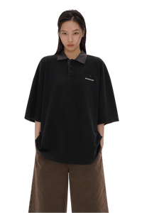 Masonprince SS25 Polo Tee in black with checkered collar worn by model with hands in pockets