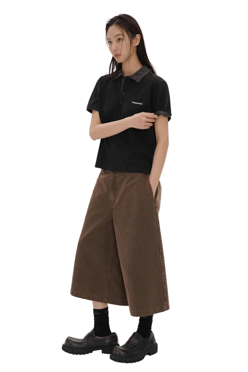 Woman wearing Masonprince SS25 Polo Tee in black paired with wide brown cropped pants and black shoes