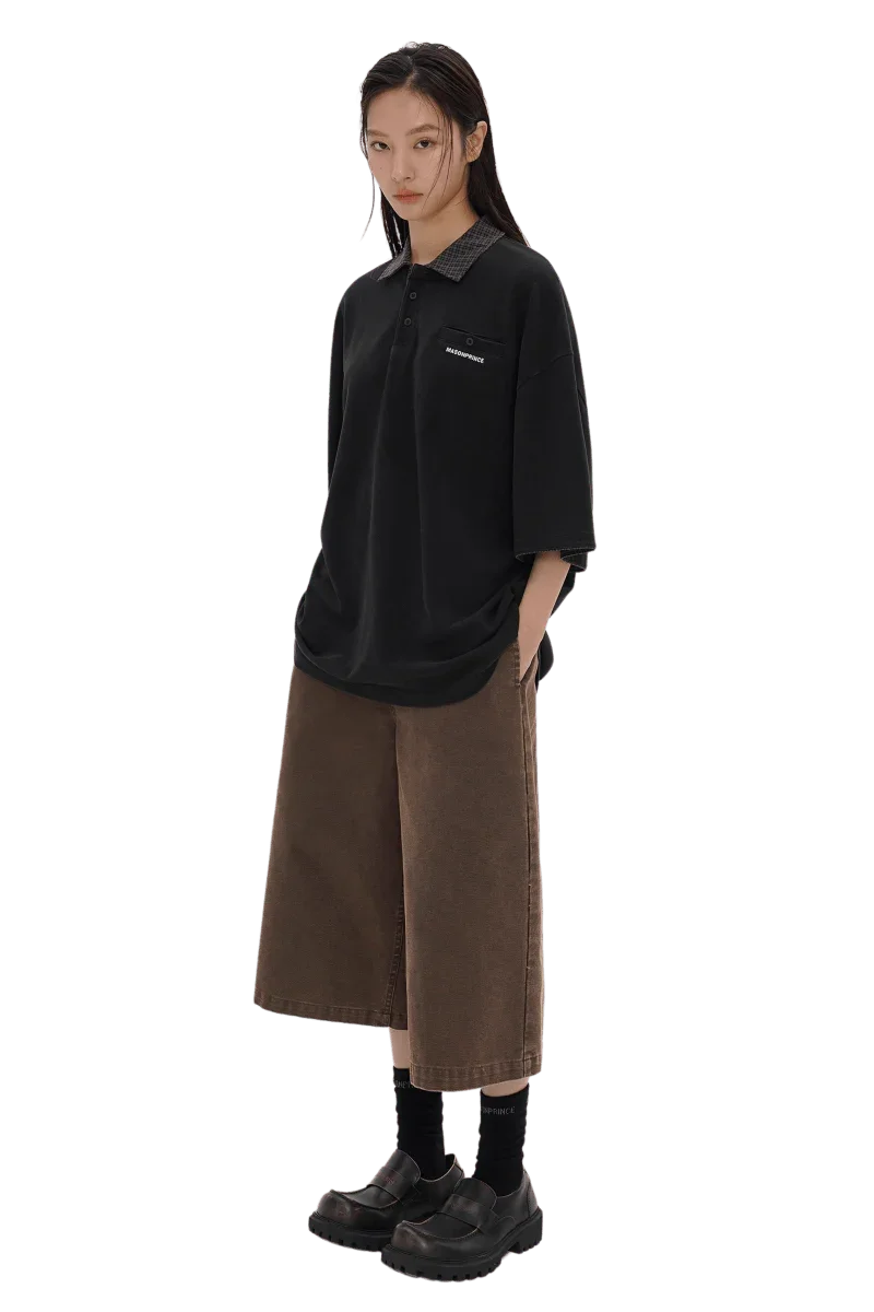 Stylish black Masonprince SS25 Polo Tee with short sleeves worn by a model with brown wide-leg pants