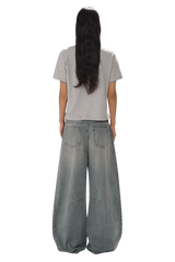 Back view of model wearing Masonprince SS25 Polo Tee in gray with wide leg denim jeans