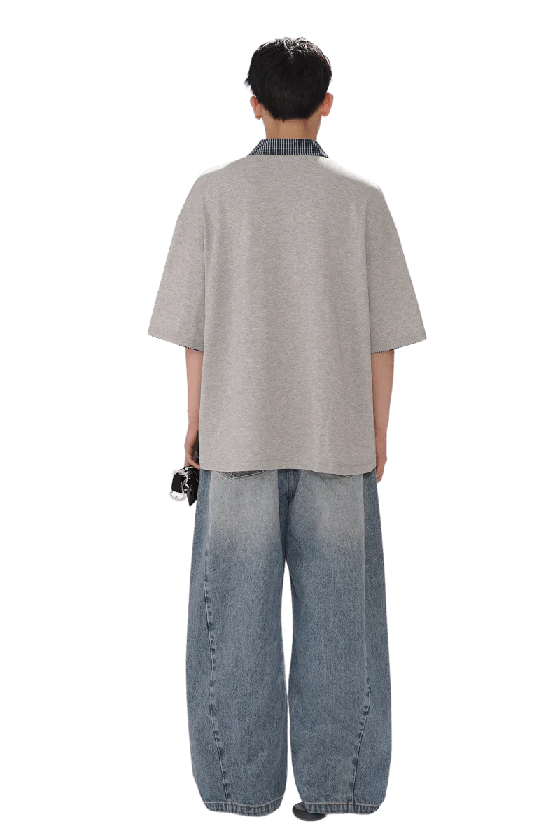 Back view of a person wearing Masonprince SS25 Polo Tee with loose grey short sleeves and blue wide jeans