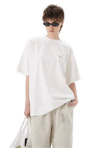 Model wearing Masonprince SS25 Tape Tee white oversized t-shirt with sunglasses and light beige pants